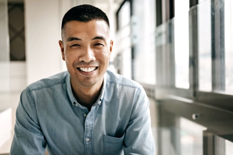 Asian man smiling wearing blue shirt