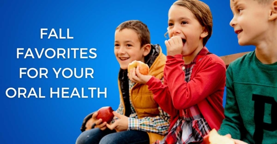 Kids sitting on a bench together, eating apples