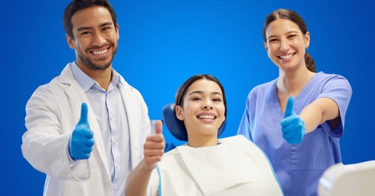 Dental hygienist and assistant with patient