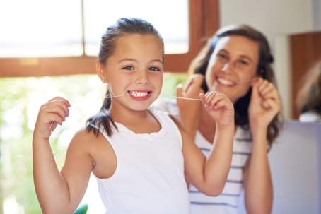 little girl and mom flossing