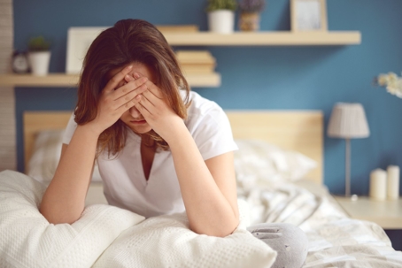 woman sitting up in bed stressed