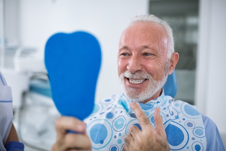 man looking in mirror dentist smile