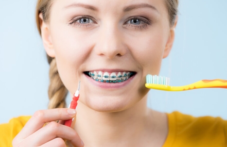 kid cleans braces with tooth brush
