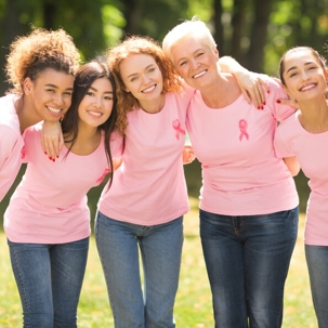 group of women wearing pink breast cancer ribbon shirts